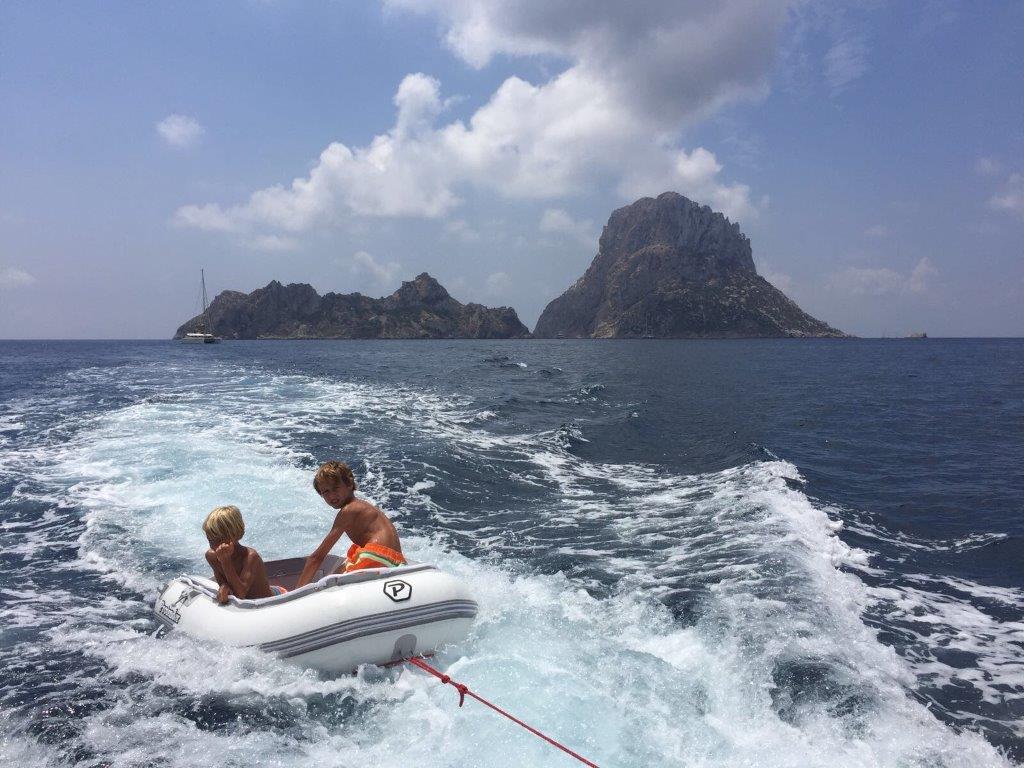 Smiling children in a dinghy while sailing in Ibiza with our boat for rent